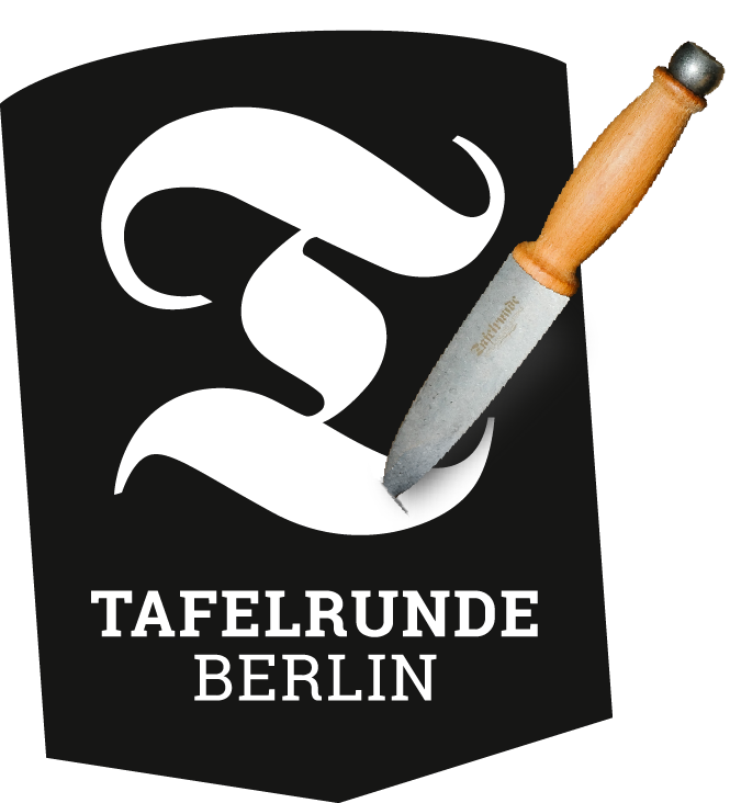 Tafelrunde Berlin logo on a black shield: a white curved emblem being sliced by a kitchen knife, with the words ‘TAFELRUNDE BERLIN’ beneath.